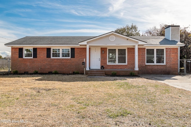 ranch-style home featuring brick siding, a front lawn, a chimney, and fence