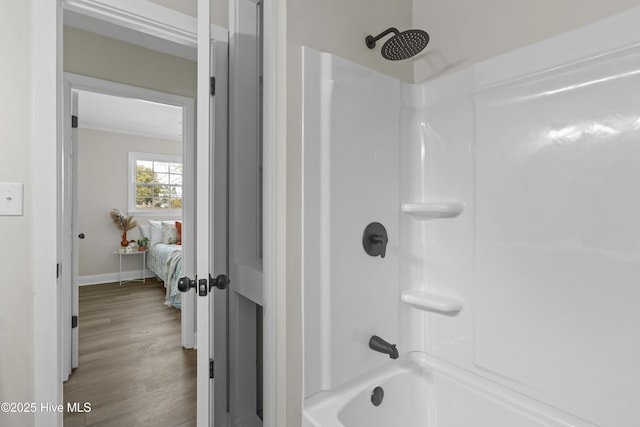 bathroom with shower / tub combination, baseboards, and wood finished floors