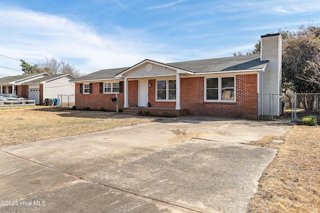 ranch-style home featuring brick siding, a chimney, a front yard, and fence