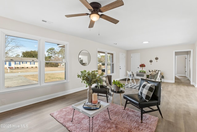 living area featuring light wood-style floors, visible vents, baseboards, and recessed lighting