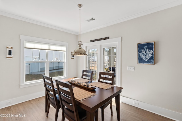 dining space featuring hardwood / wood-style flooring and ornamental molding