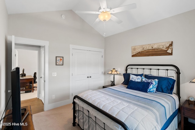 carpeted bedroom with lofted ceiling, a closet, and ceiling fan