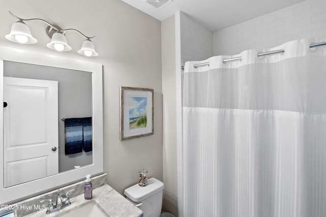 bathroom featuring vanity, curtained shower, and toilet