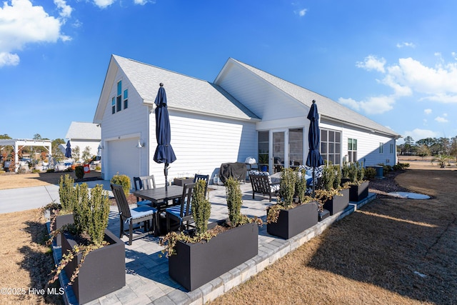 view of side of home featuring a garage and a patio area