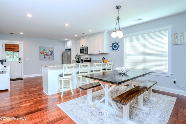 dining room with sink and dark hardwood / wood-style flooring