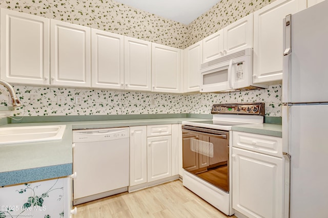 kitchen featuring white cabinetry, sink, white appliances, and light hardwood / wood-style floors