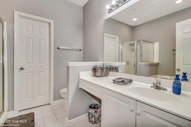 bathroom featuring toilet, tile patterned flooring, walk in shower, and vanity