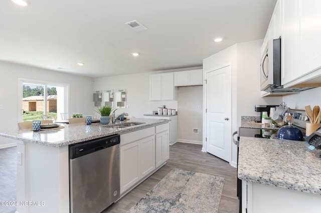 kitchen featuring appliances with stainless steel finishes, sink, white cabinetry, and a center island with sink