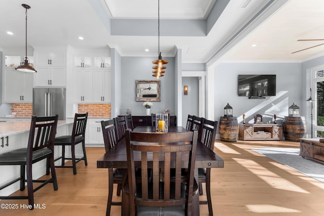 dining area with crown molding, ceiling fan, and light hardwood / wood-style flooring