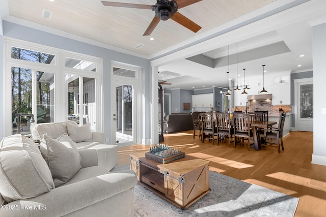 living room with wood ceiling, ceiling fan, crown molding, and light hardwood / wood-style floors