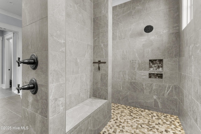 bathroom featuring crown molding and a tile shower