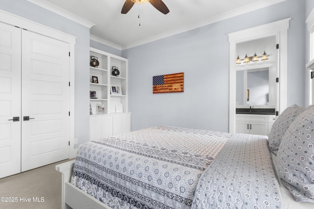 carpeted bedroom with ensuite bathroom, sink, ornamental molding, ceiling fan, and a closet