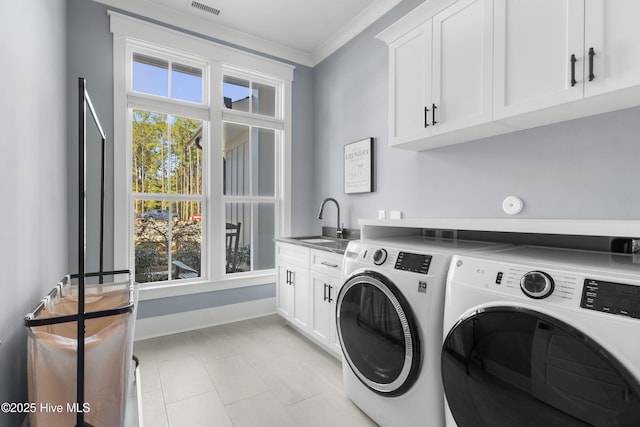 clothes washing area featuring sink, cabinets, separate washer and dryer, ornamental molding, and a wealth of natural light