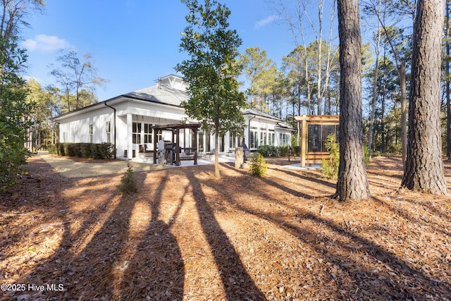 rear view of property with a patio area and a sunroom