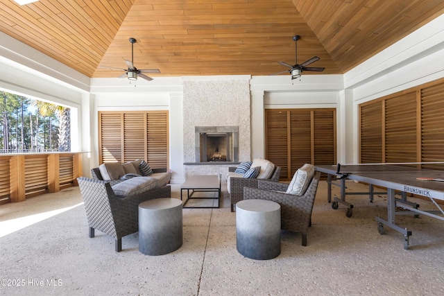 view of patio / terrace featuring ceiling fan and an outdoor living space with a fireplace