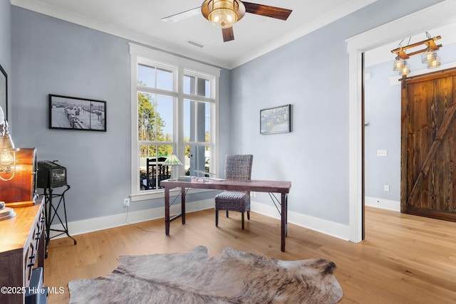 home office with crown molding, ceiling fan, and light hardwood / wood-style flooring