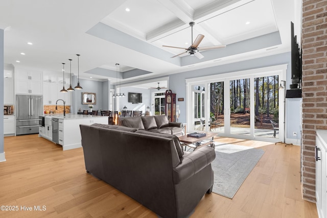 living room featuring coffered ceiling, ceiling fan, light hardwood / wood-style flooring, and beamed ceiling