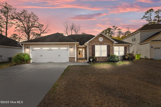 single story home with cooling unit, a yard, and a garage