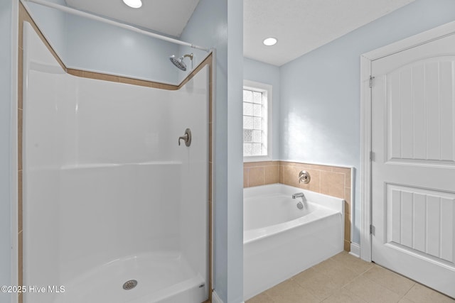 bathroom featuring shower with separate bathtub and tile patterned flooring