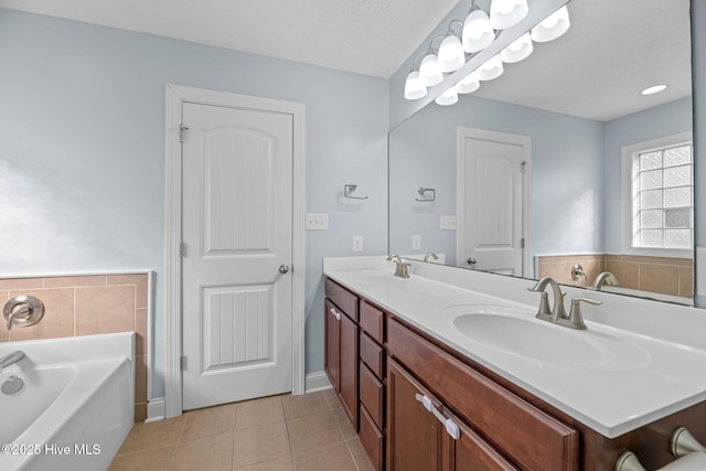 bathroom featuring vanity, tile patterned flooring, and a tub