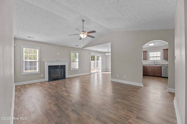 unfurnished living room with dark hardwood / wood-style floors, sink, and a wealth of natural light