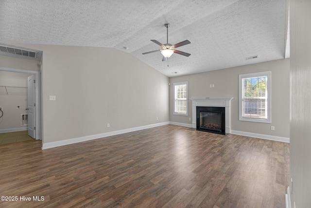 unfurnished living room with lofted ceiling, dark hardwood / wood-style floors, a textured ceiling, and ceiling fan