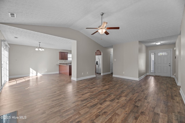 unfurnished living room with vaulted ceiling, dark wood-type flooring, ceiling fan with notable chandelier, and a textured ceiling