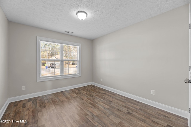 unfurnished room with dark hardwood / wood-style floors and a textured ceiling