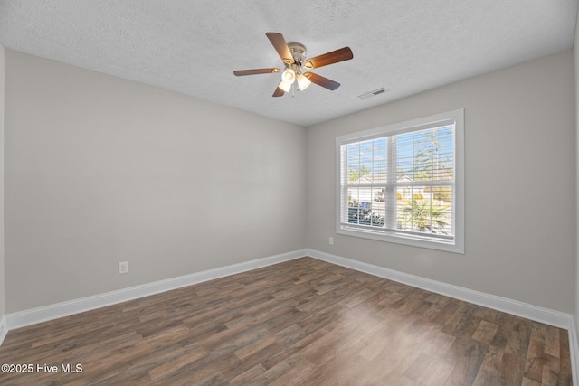 spare room featuring ceiling fan, dark hardwood / wood-style floors, and a textured ceiling