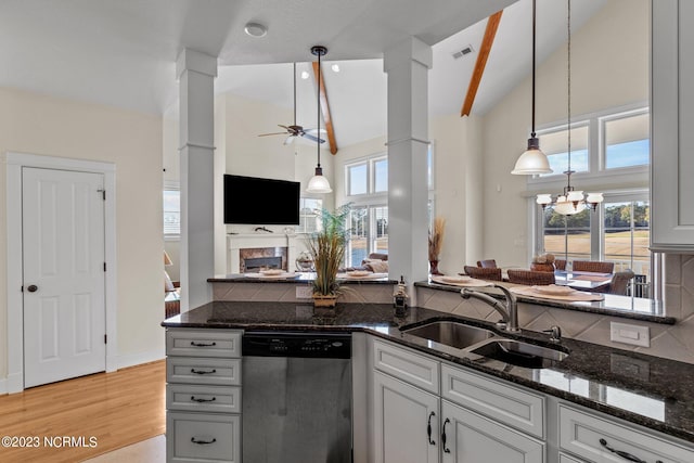 kitchen with sink, pendant lighting, dishwasher, and dark stone counters