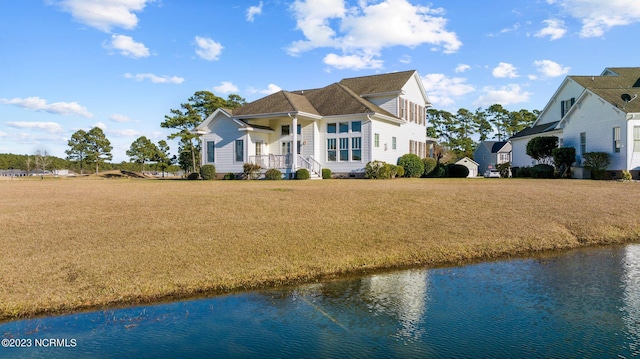 view of front facade featuring a water view and a front lawn