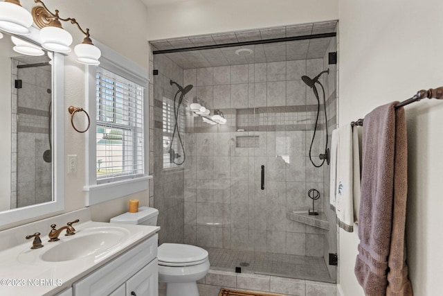 bathroom with toilet, a shower with shower door, tile patterned floors, and vanity