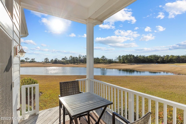 wooden deck featuring a lawn and a water view