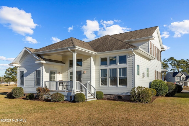 rear view of property featuring a porch and a lawn