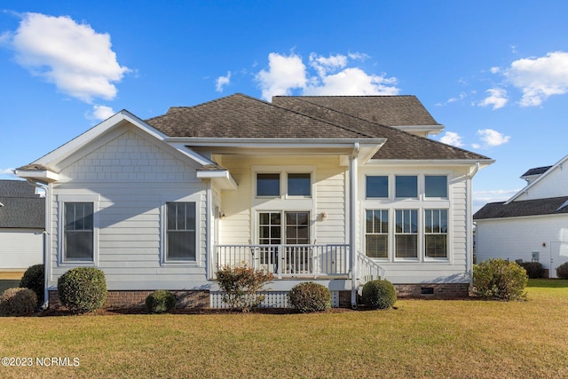 back of property featuring a lawn and a porch