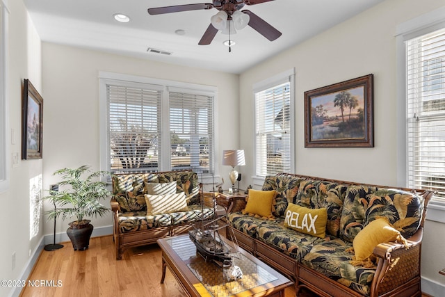 living room featuring light wood-type flooring and ceiling fan