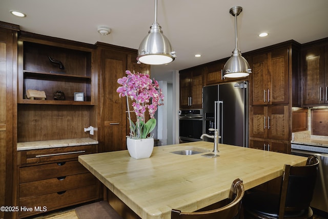 kitchen with dark brown cabinets, sink, stainless steel appliances, and wooden counters