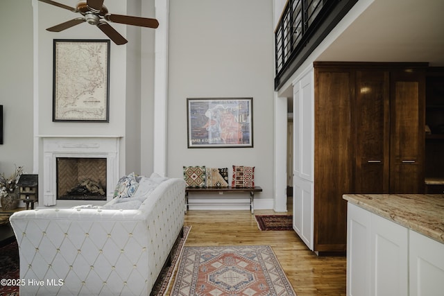 living room with light wood-type flooring and ceiling fan