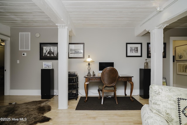 office space with light hardwood / wood-style floors and ornate columns