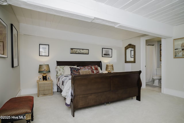 bedroom featuring ensuite bathroom and light carpet