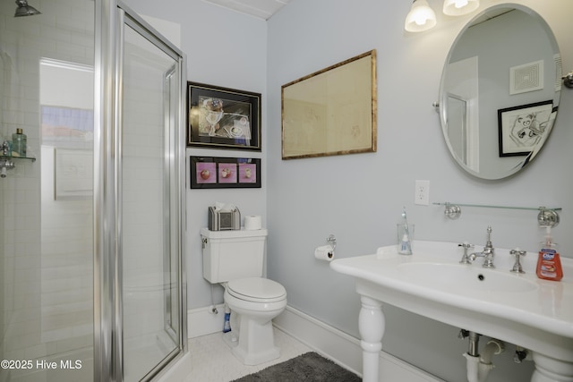 bathroom with toilet, tile patterned flooring, and a shower with door