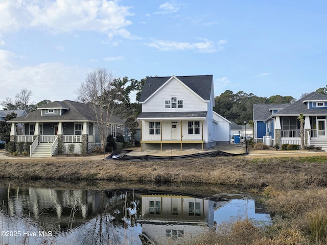 rear view of house with a water view and covered porch