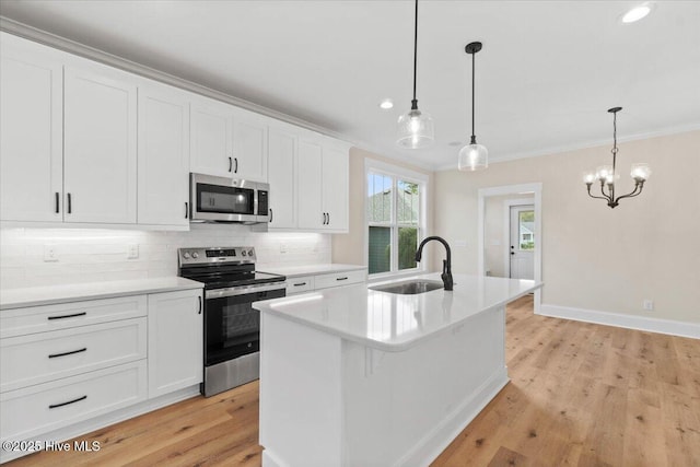1665 Butterfly Knot Dr SW, Ocean Isle Beach, NC 28469 - kitchen with a sink, appliances with stainless steel finishes, tasteful backsplash, white cabinets, and light wood finished floors