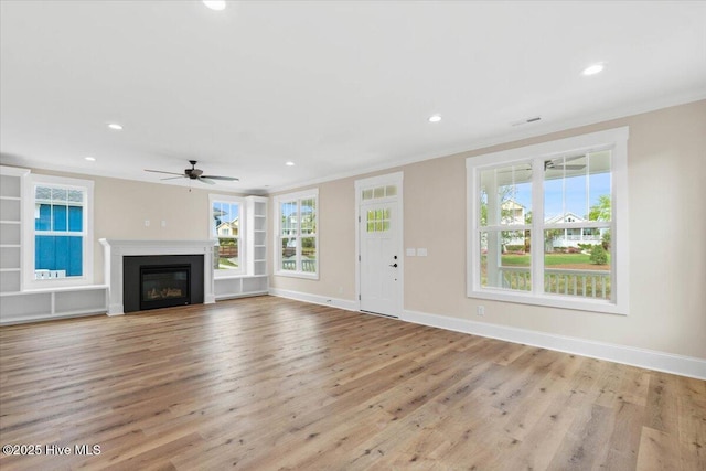 1665 Butterfly Knot Dr SW, Ocean Isle Beach, NC 28469 - unfurnished living room with ornamental molding, ceiling fan, recessed lighting, wood finished floors, and a glass covered fireplace