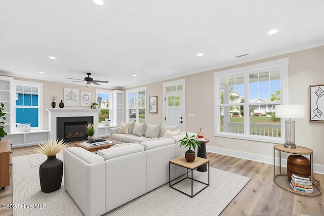 1665 Butterfly Knot Dr SW, Ocean Isle Beach, NC 28469 - living area featuring ceiling fan, wood finished floors, a glass covered fireplace, recessed lighting, and healthy amount of natural light