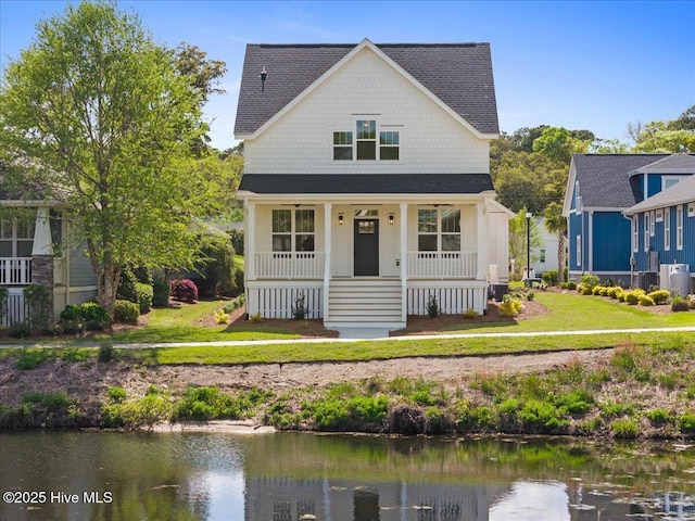 1665 Butterfly Knot Dr SW, Ocean Isle Beach, NC 28469 - view of front of house featuring covered porch, a water view, central AC, and a front yard