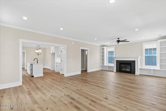 1665 Butterfly Knot Dr SW, Ocean Isle Beach, NC 28469 - unfurnished living room featuring ceiling fan, light wood-style floors, crown molding, recessed lighting, and a glass covered fireplace