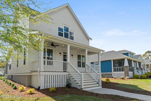 1665 Butterfly Knot Dr SW, Ocean Isle Beach, NC 28469 - view of front of home with a ceiling fan, board and batten siding, a porch, stairway, and a sunroom