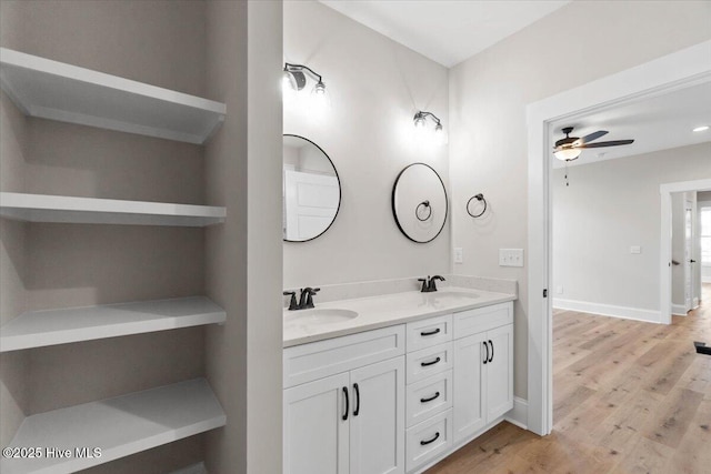 1665 Butterfly Knot Dr SW, Ocean Isle Beach, NC 28469 - bathroom featuring ceiling fan, wood finished floors, double vanity, and baseboards