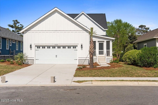 1665 Butterfly Knot Dr SW, Ocean Isle Beach, NC 28469 - view of front facade featuring board and batten siding, a garage, driveway, and a sunroom